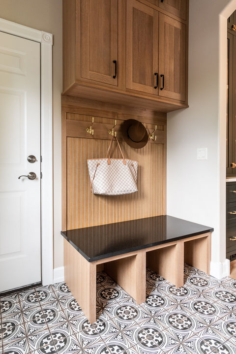 Mudroom bench with oak cabinetry, quartz bench, and patterned tile by Laura Lien Interior Design