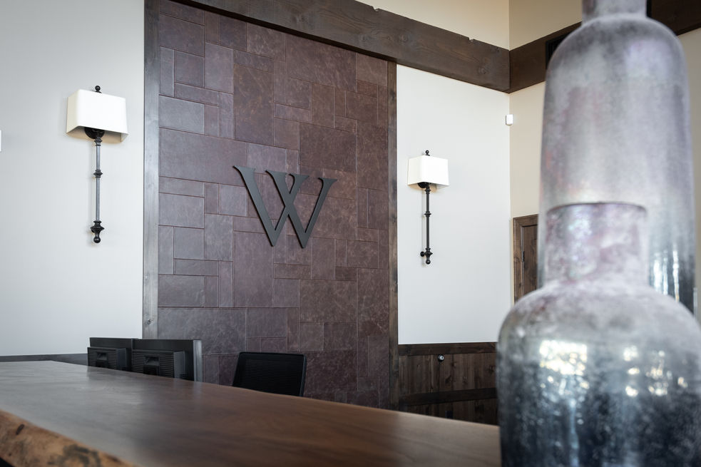 Leather wall detail with logo and sconces 
