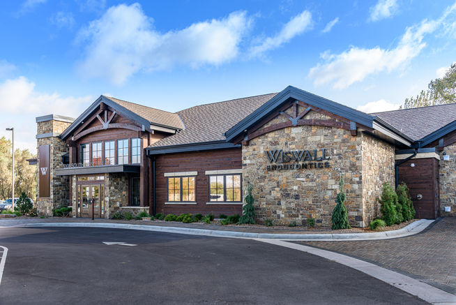 Exterior close-up of commercial building with stone, wood, and signage by Laura Lien Interior Design