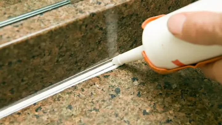 uomo che applica un silicone