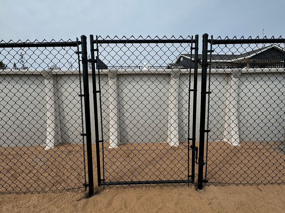 Close-up of a black chain link fence with a self-closing gate, ensuring security and compliance with HRM pool safety regulations.
