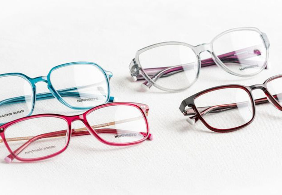 A photo of a woman trying on contact lenses and glasses to compare vision clarity.