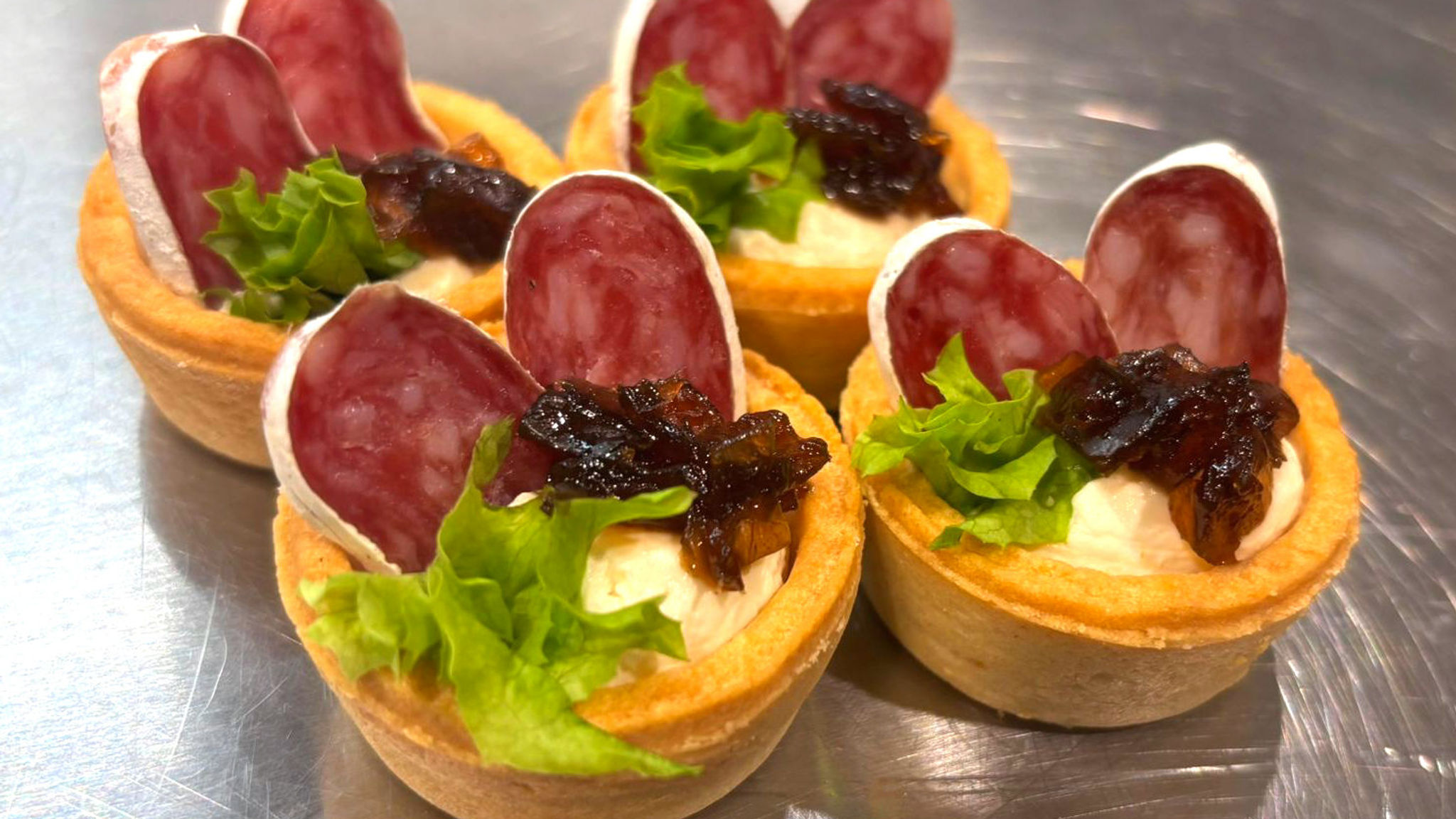 Slaný koláček - Fuet, cibulové chutney a krémový sýr. (Minimální množství 24ks)