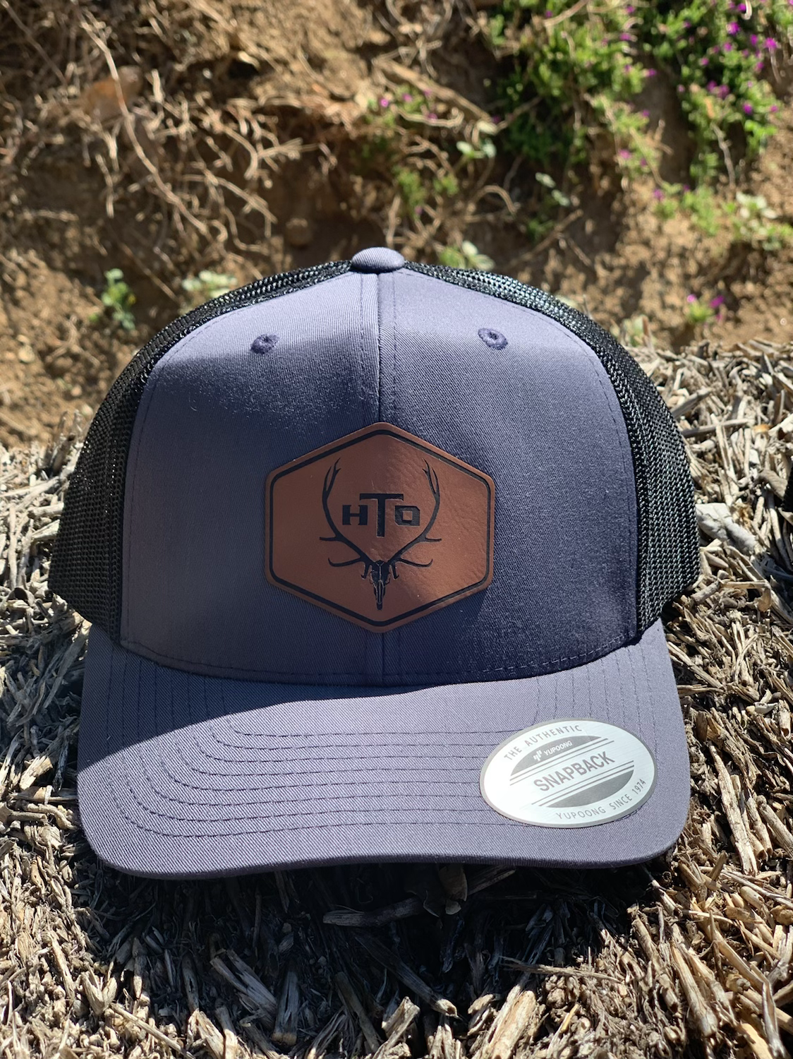 Grey on black leather patch trucker hat