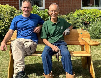 two men sitting on hand crafted oak bench