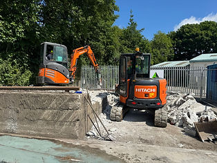 Two mini diggers clearing rubble