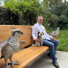 artist sitting on his hand crafted osprey bench