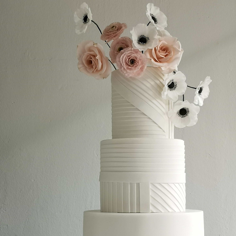 Minimalist White 3 Tier Wedding Cake with Sugar Flowers at the Top