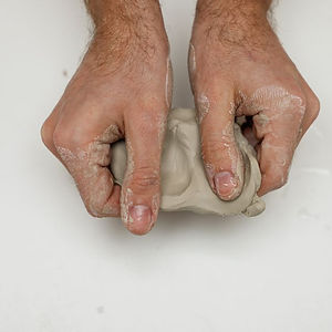 Close up of hands kneeding clay