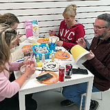 Adults painting ceramics at Crafty Monkey Pottery Painting Studio in St. Neots
