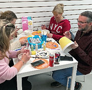 Adults painting ceramics at Crafty Monkey Pottery Painting Studio in St. Neots