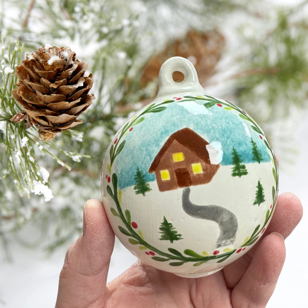 Bauble with a Christmas house design painted on.