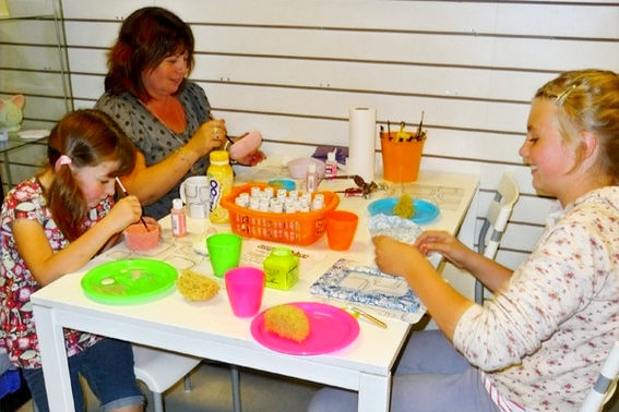 People painting pottery in the Crafty Monkey Pottery Studio in St Neots