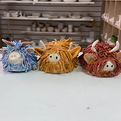 Three highland cows made at a Crafty Monkey Pottery class