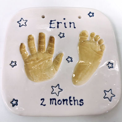 Baby hand and footprint clay impressions with stars in background