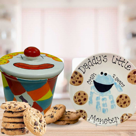 A plate with a baby hand print that has been turned into the cookie monster.