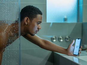Man checking his phone while showering