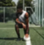 Kofi Schulz crouching with a football on a training pitch.