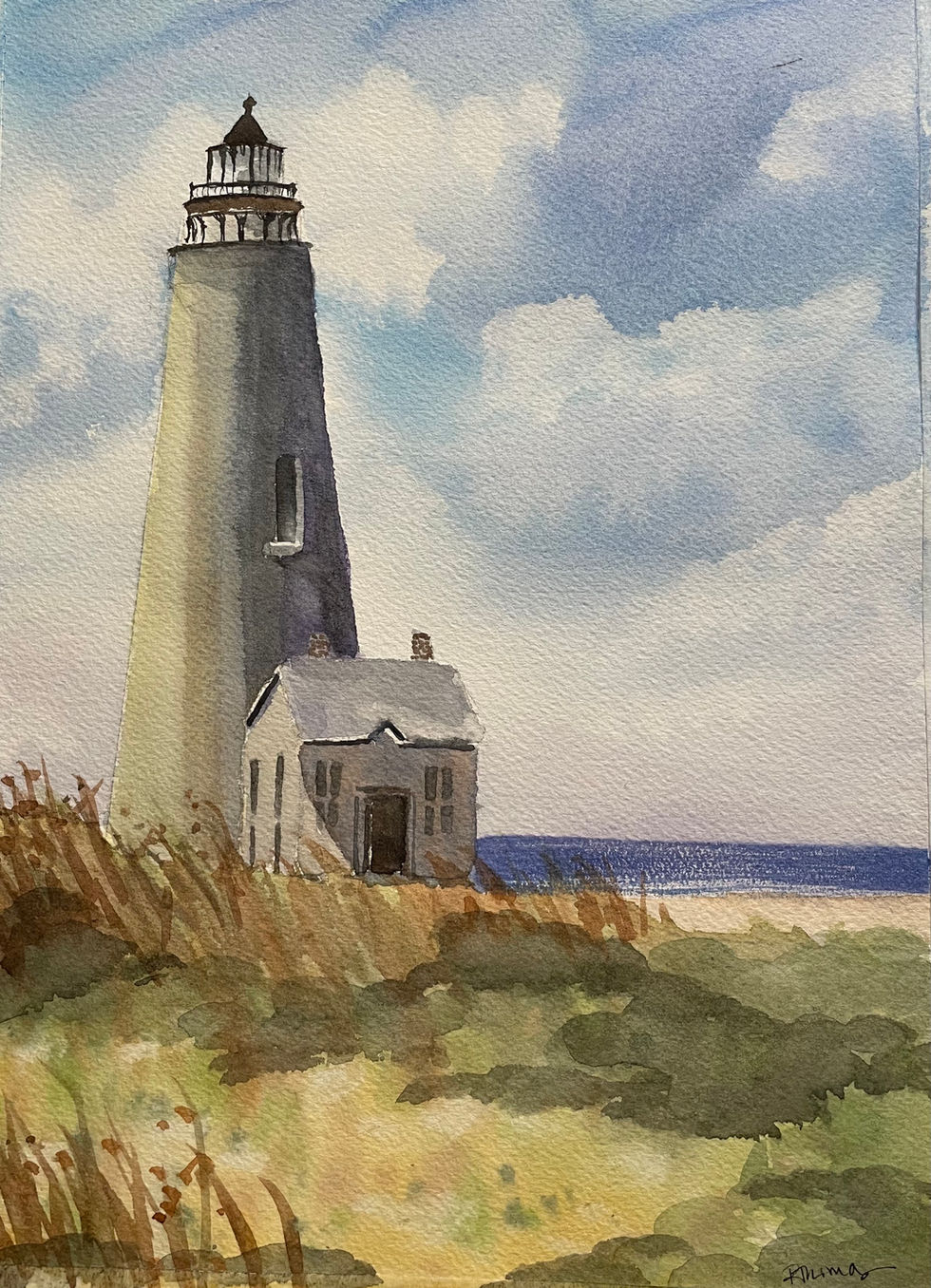A peek of a seascape with bright blue water and a fluffy clouds behind a Cape Cod lighthouse and dunes.