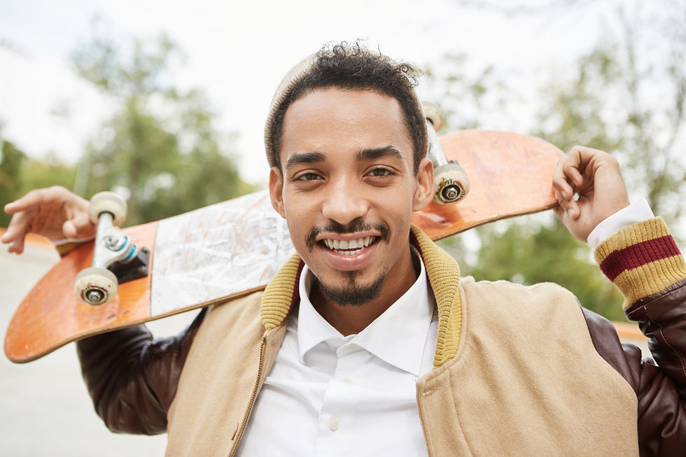 Young man holding a skateboard outdoors, representing confidence, identity, and personal growth during the recovery journey