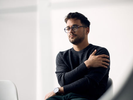 Man sitting quietly before a counseling session, representing the emotional burden and mental health struggles that can accompany alcohol recovery