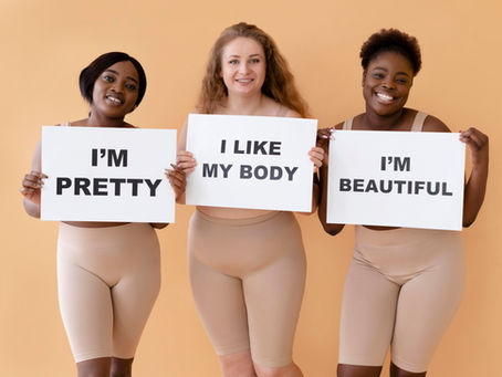 Drie vrouwen met verschillende lichaamsvormen houden borden vast met teksten 'I'm pretty, 'I like my body en I'm beautiful'.