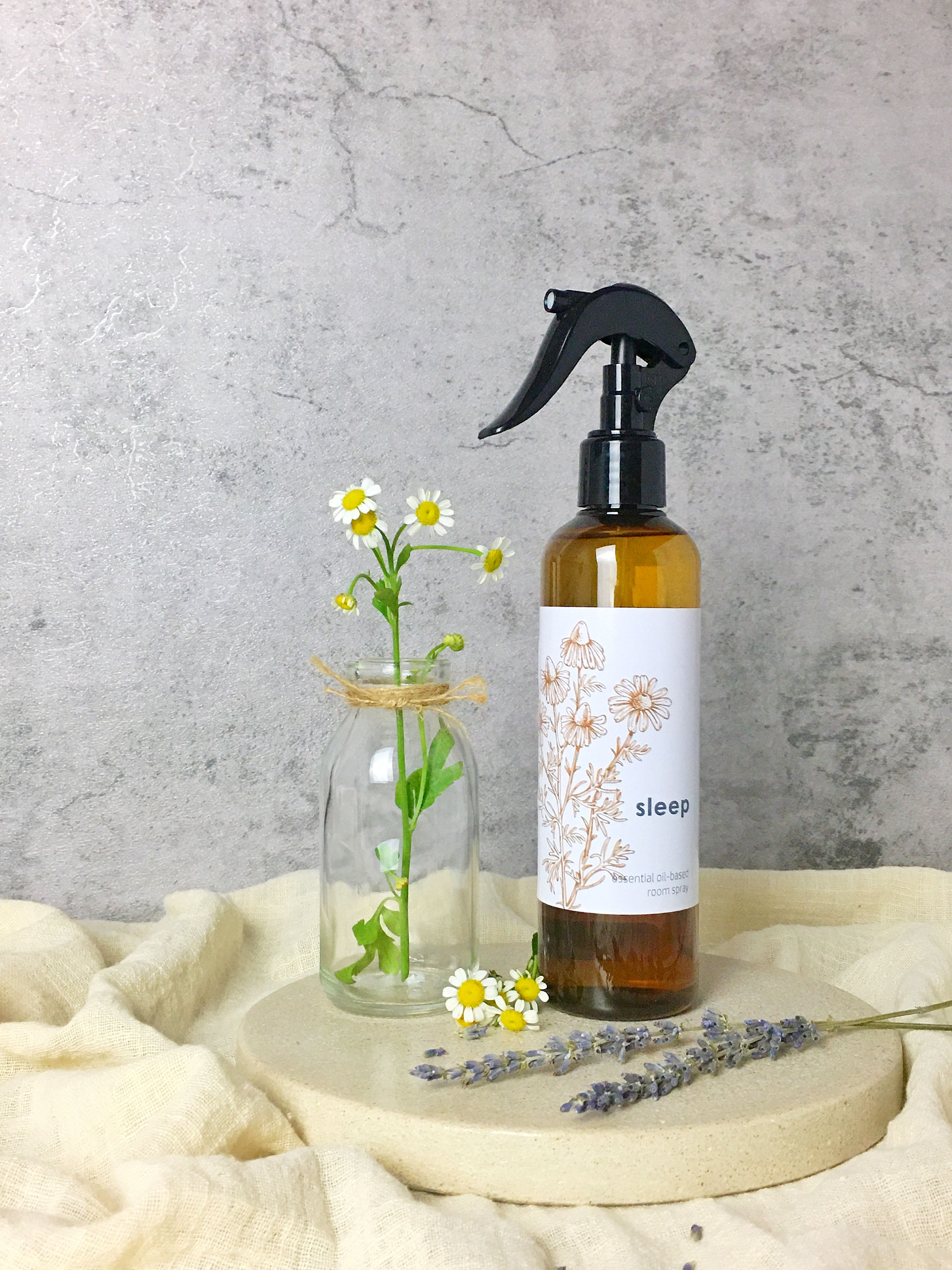 lavender chamomile sleep room spray with chamomile flowers as props