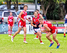 Josh Lange runs the ball out of defence in the BFNL football game between Ocean Grove and Portarlington