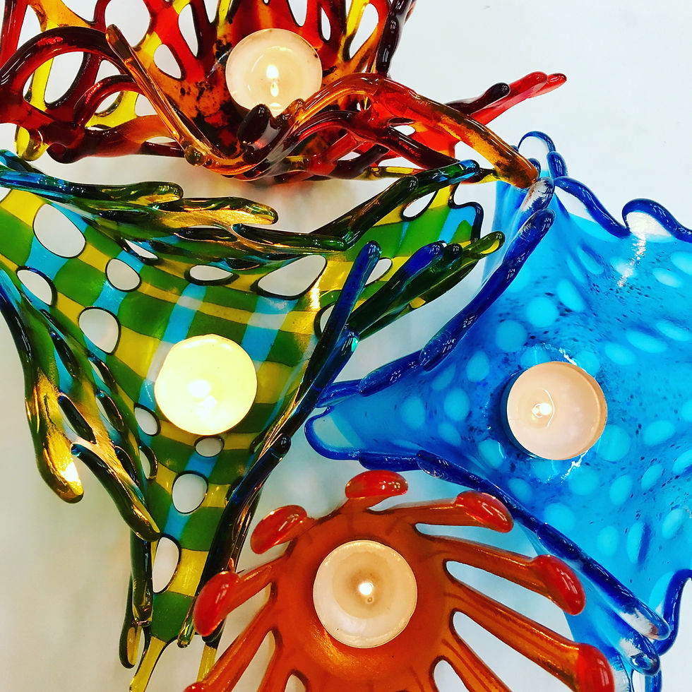 Four glowing fused glass draped vessels with night lights made at Rainbow Glass Studios N16 0JL