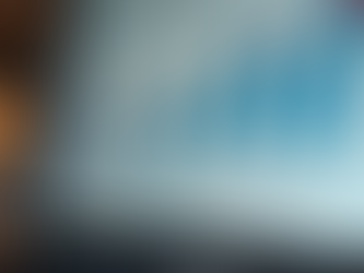 Laptop screen showing a bar graph with blue bars and a rising red line, indicating growth. Background is softly blurred with warm lights.