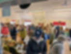 People indoors looking at craft stalls