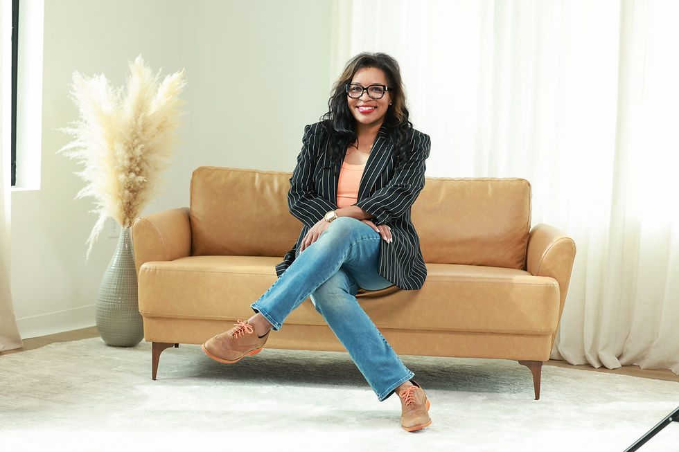 Author and speaker Shannon Nicole sitting confidently on a leather couch during a professional photoshoot