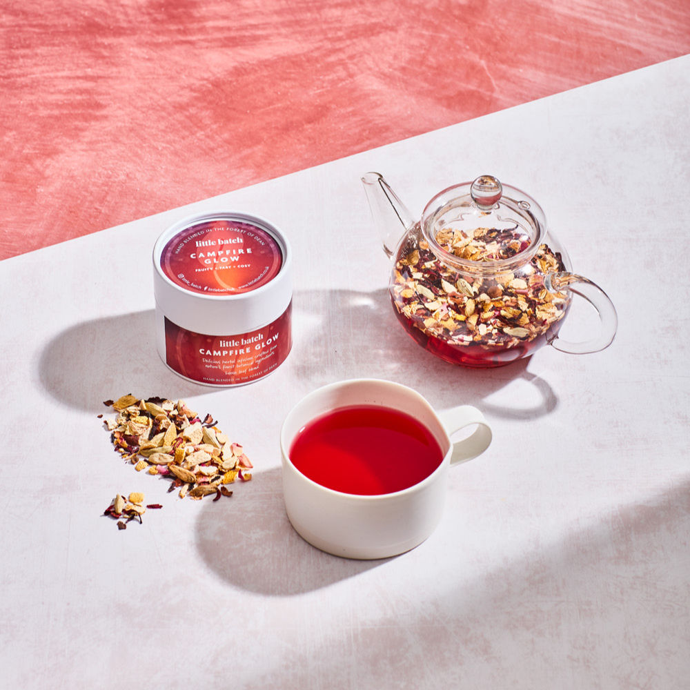 Campfire Glow herbal tea regular size tub with a mug of brewed tea