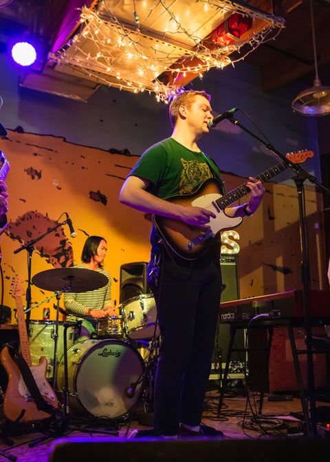 Band performing live on stage with guitars and keyboards
