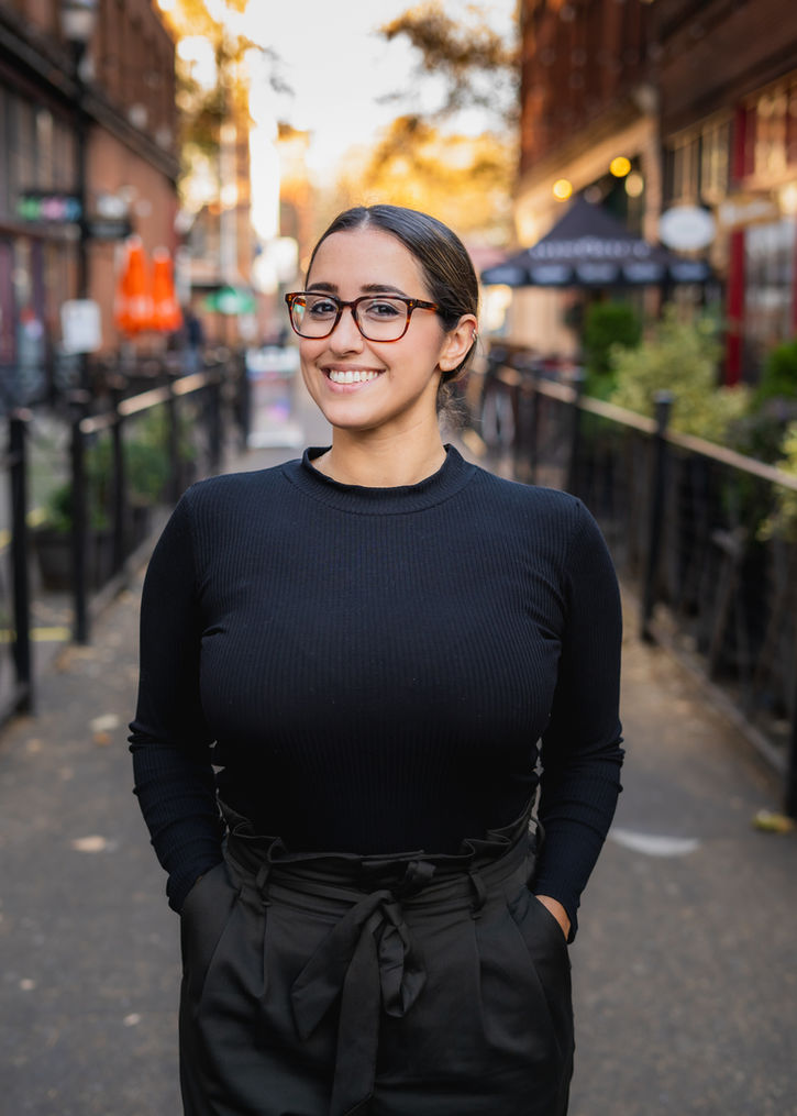 Smiling woman wearing glasses, black top and pants