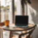 a sun lit background with laptop on table with chair.jpg