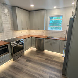Contemporary kitchen, Luxury kitchen, high end kitchen remodel, gray wood cabinets, butcher block kitchen countertops, kitchen remodeler in western ma, kitchen renovations in western ma, stainless steel range, stainless range hood, luxury vinyl wood floor, white subway tile backsplash in kitchen, open shelving in kitchen, undercabinet lighting in kitchen, under cabinet kitchen lighting