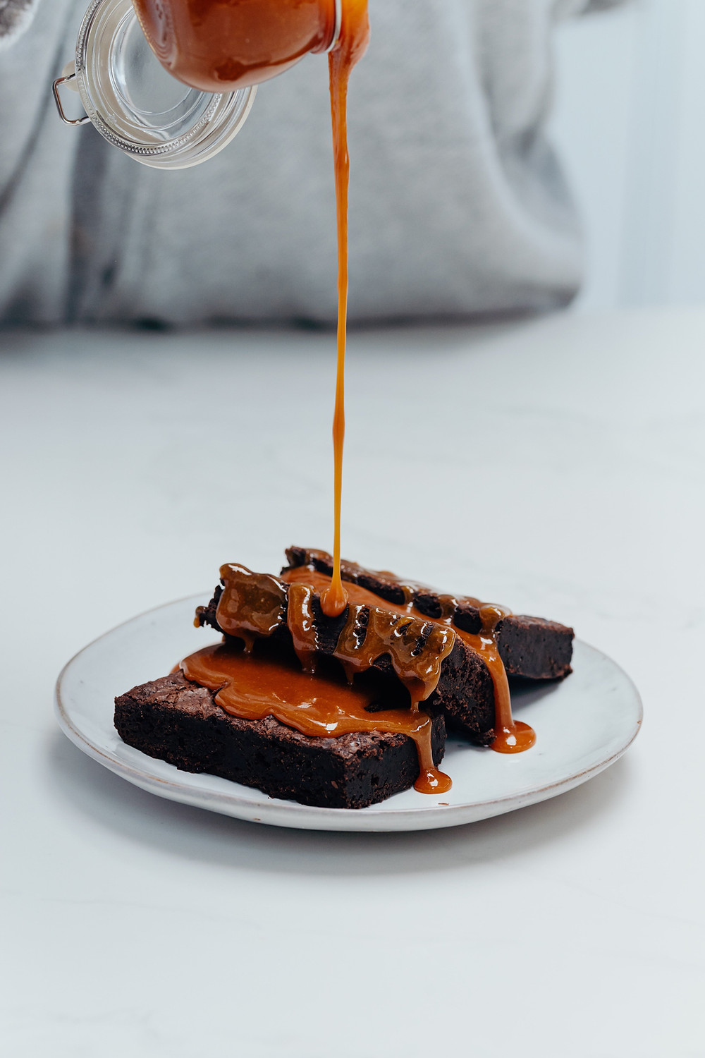 Salted Caramel brownie having gooey caramel sauce poured over it.