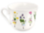 Rückseite derselben Porzellantasse mit weiteren floralen Feenmotiven. Zu sehen sind eine Fee mit Krokus, eine mit Löwenzahn, eine mit rosa Punkten und eine blaue Fee mit Vergissmeinnicht. In der Tasseninnenseite ist zusätzlich eine zart gemalte Blume abgebildet. Der Stil ist filigran und märchenhaft.