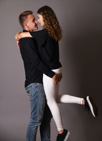 Ein Mann hebt seine Partnerin hoch und beide schauen sich mit den Nasenspitzen fast berührend tief in die Augen.