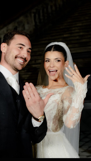 noivos Ana Carolina e Vicente, exibindo suas refinadas alianças e trajados com vestido de alta costura e terno de alfaiataria de luxo