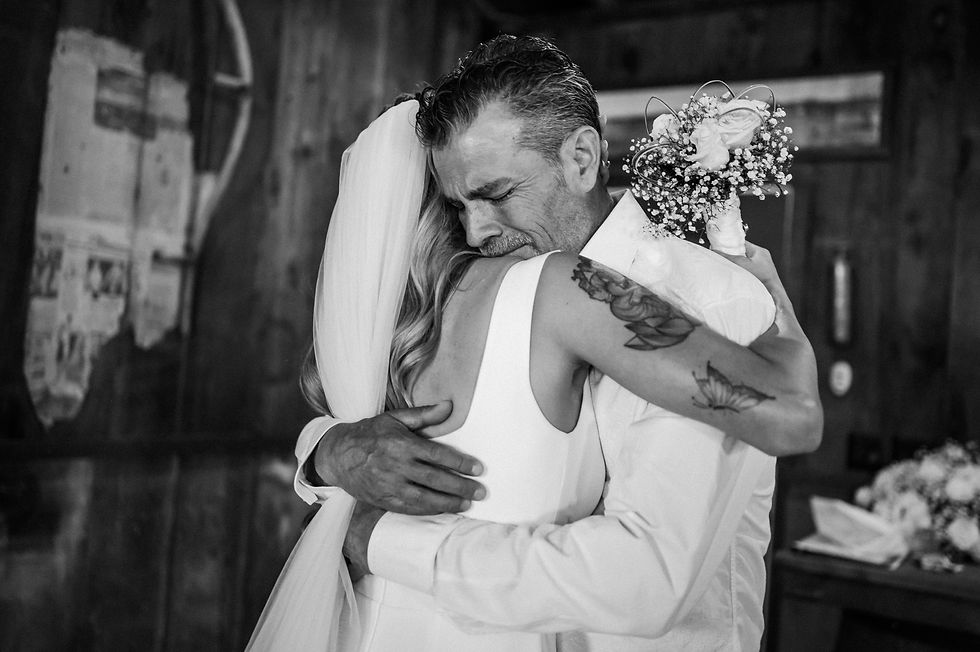 Father of the bride hugs his daughter during a first look at Almond Springs Ranch.