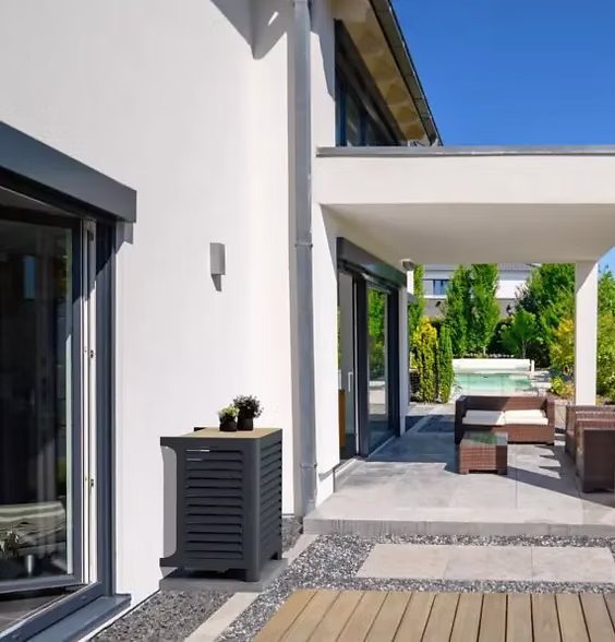 Outdoor heat pump cover integrated with garden patio design — heat pump protection from Marlow Stoves.