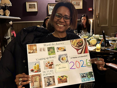 Leila smiling proudly, holding a 2026 vision board with motivational words and pictures