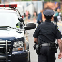 A police officer walking by his patrol car
