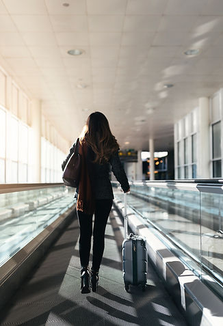 unrecognizable-woman-walking-with-suitcase-airport-business-concept.jpg