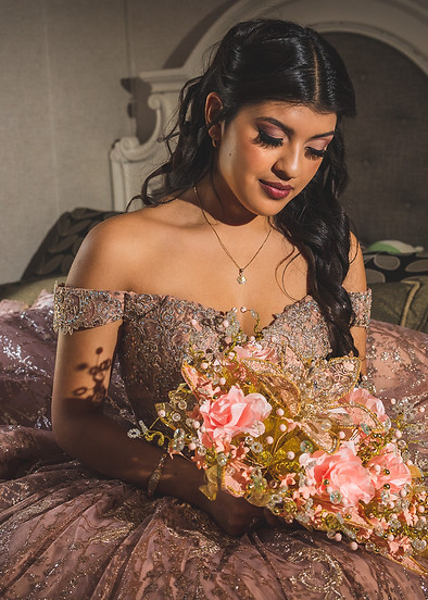 Young woman in quinceanera dress on bed