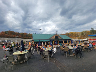 Dark clouds over diners seated in front of pavilion during a cool-weather gathering