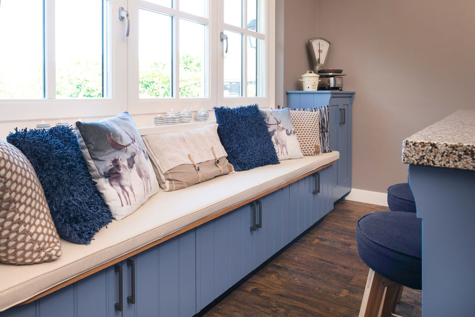 een lange blauwe bank in een landelijke keuken