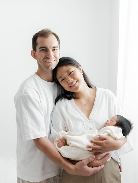 Parents holding their newborn baby during a family photography session in Greenwich studio